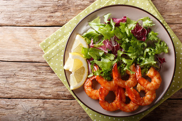 Shrimp fried in soy sauce and fresh salad close-up. horizontal top view