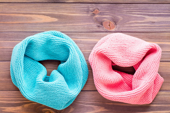 Mint snud and pink snud on a wooden background. Top view