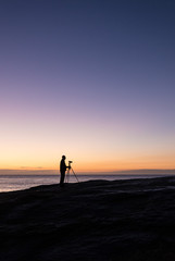 Photographer at dawn at the Bow Hole, Tasmania