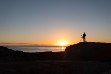 Photographer at dawn at the Bow Hole, Tasmania