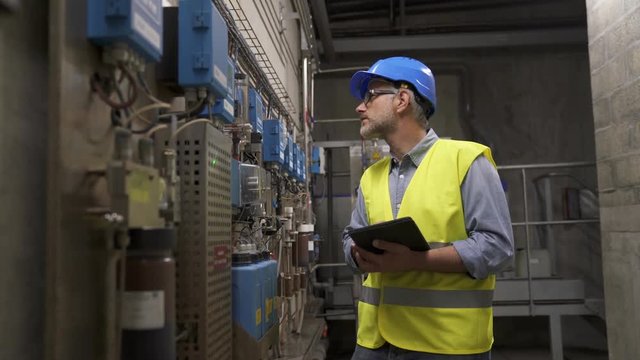 Industrial technician connected with tablet in recyling plant
