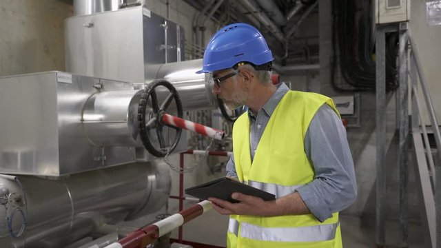 Industrial technician connected with tablet in recyling plant