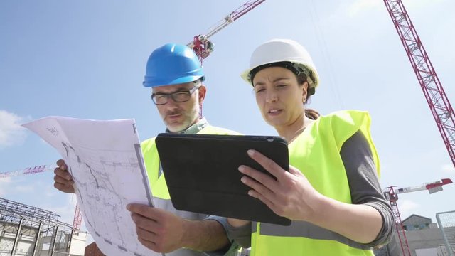 Construction manager and engineer working on building site