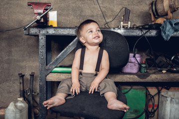 Fototapeta na wymiar Mechanic Baby Boy - Sitting on the chair.