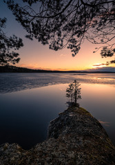 Malerische Landschaft mit schmelzendem See und Sonnenuntergang am schönen Frühlingsabend in Finnland