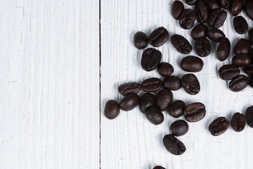 Roasted coffee beans on white wood table. coffee background with copy space.