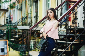 Portrait of a young girl in the city . Girl in jeans and blouse on the streets