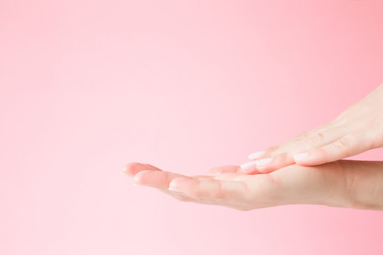 Beautiful, groomed woman's hand touching her perfect, smooth skin. Care about clean and soft hands skin. Beauty concept. Pink background.