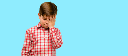 Handsome toddler child with green eyes stressful keeping hand on head, tired and frustrated over...