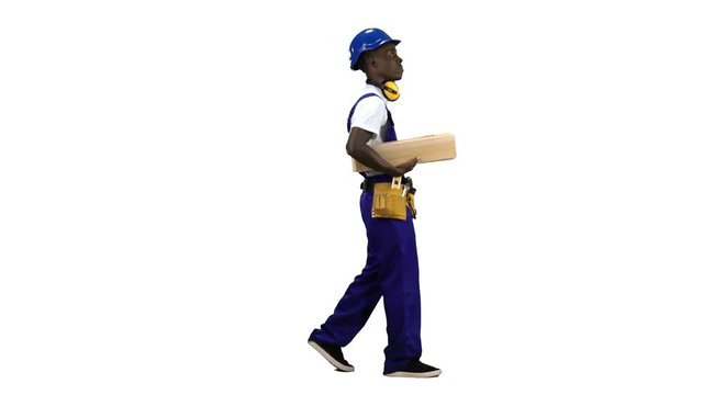 Builder african american goes to work with wooden planks in his hands. Alpha channel. Side view