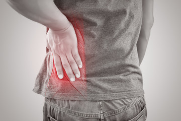 Asian man suffering from muscle waist pain injury, People with back pain symptoms against gray...