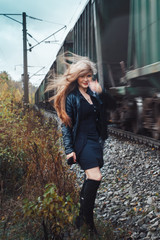 Nice girl on a railway road near moving train