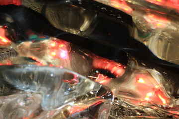 An image of an ice wall with frozen multicolored lamps.