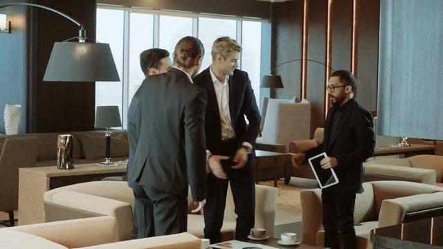 One man saying goodbye and shaking hands to three businessmen after a business meeting. 4K