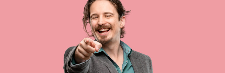 Handsome young man pointing to the front with finger