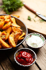Baked potato fries on wooden table