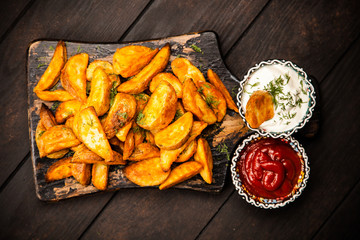 Baked potato fries on wooden table