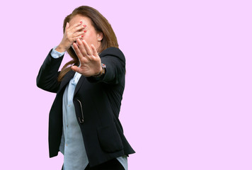 Middle age business woman stressful and shy keeping hand on head, tired and frustrated