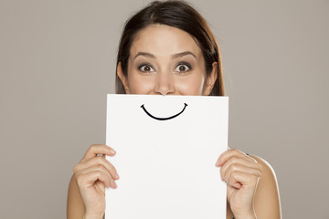 Naklejka premium happy and smiling girl with a smile painted on paper