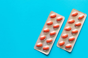 Two packs of pills on a blue background . The concept of health