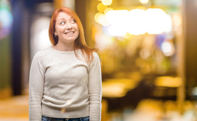 Beautiful young redhead woman confident and happy with a big natural smile laughing at night