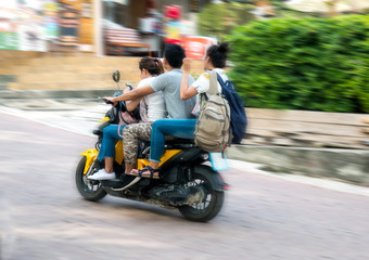 drei Personen auf einem Roller in Thailand, Asien.