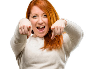 Beautiful young redhead woman pointing to the front with finger isolated over white background