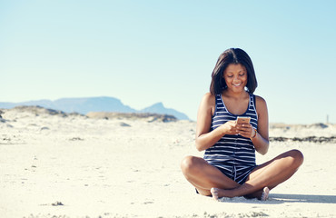 Fototapeta na wymiar girl checking smartphone on beach