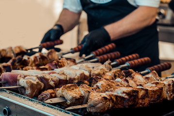 the man bakes the meat on the grill