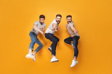 Fototapeta na wymiar Three young cheerful men jumping together