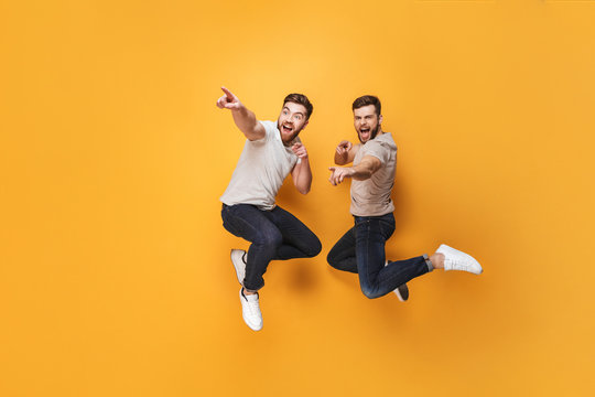 Two young cheerful men jumping together