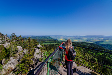 Woman tourist taking photo of Szczeliniec Wielki mountain