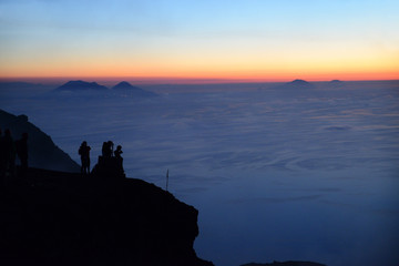 Pleople on the summit of Volcano Stromboli enjoying the sunset and view of the Aeolian Islands,...