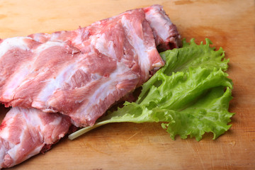 Raw Ribs on a rustic cutting board with salt, pepper and grinder for spices . copy space. Top View.