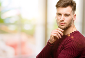 Handsome young man thinking thoughtful with smart face