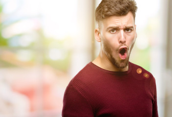 Handsome young man happy and surprised cheering expressing wow gesture