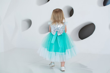  A LITTLE GIRL IN A BLUE DRESS SMILES