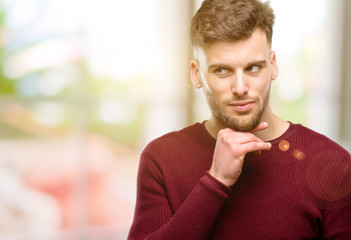 Handsome young man thinking thoughtful with smart face, expressing question and doubt. Imagine the solution