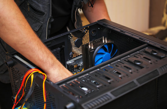 Computer technician installs system of computer. Assembling PC