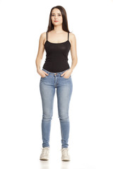 Obraz premium young woman in jeans and shirt stands on a white background