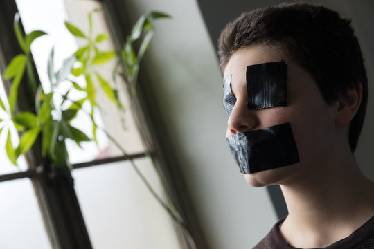 Boy With Tape On The Mouth And Eyes