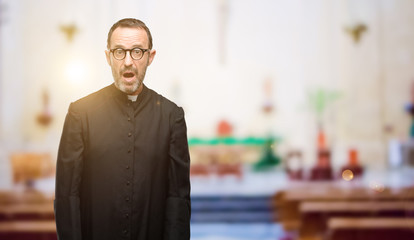 Priest religion man scared in shock, expressing panic and fear at church
