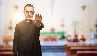 Priest religion man annoyed with bad attitude making stop sign with hand, saying no, expressing...