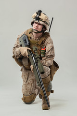 Soldier in camouflage holding rifle