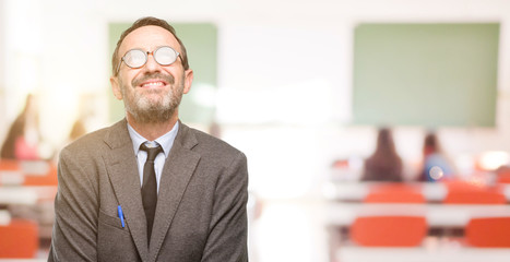 Teacher man using glasses thinking and looking up expressing doubt and wonder at classroom