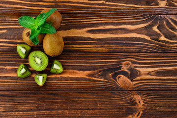 Fresh kiwi fruits on a wooden background. Space for text or design.