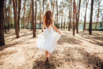 sexy bride runs in her dress in forest