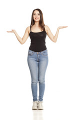 advertising young woman in jeans and shirt stands on a white background