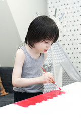 Little 5 years boy painting at home