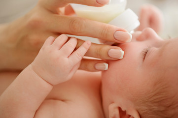 Nursing a baby. Feeding the newborn with formula in a bottle. Breastfeeding problems. Mother’s love and warmth.
